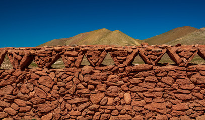 Antique vintage stone fence under clear blue sky