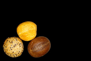 Three buns isolated on a black background. Selective focus. Space for lettering or design.