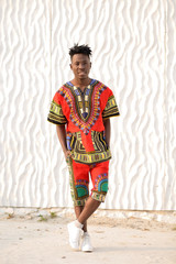 African American guy in national clothes on a background of a white wall