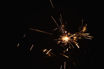 Christmas and New Year's illumination. Burning sparklers scatter bright exploding strips of sparks...