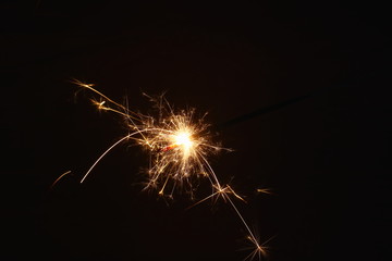 Christmas and New Year's illumination. Burning sparklers scatter bright exploding strips of sparks...