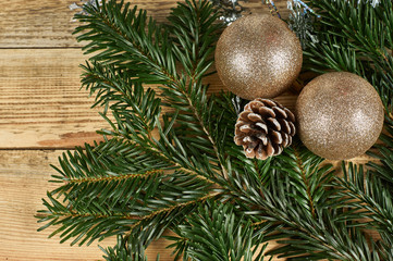 New Year's composition, Christmas decorations. Two color Christmas balls and fir cone lie on fir branches on a wooden background with copy-space