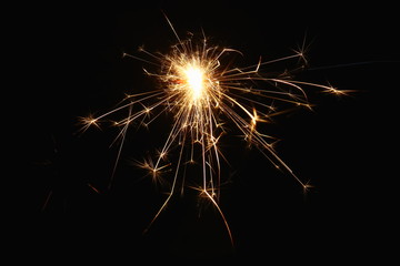 Christmas and New Year's illumination. Burning sparklers scatter bright exploding strips of sparks...