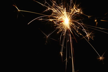 Christmas and New Year's illumination. Burning sparklers scatter bright exploding strips of sparks...