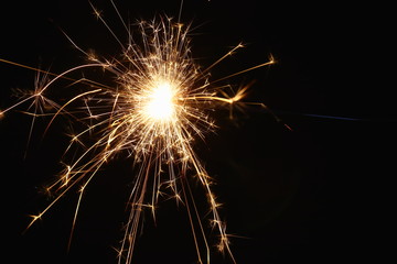 Christmas and New Year's illumination. Burning sparklers scatter bright exploding strips of sparks...