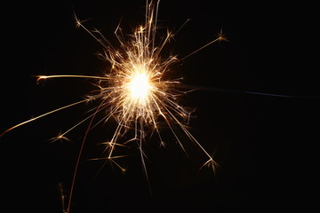Christmas and New Year's illumination. Burning sparklers scatter bright exploding strips of sparks...