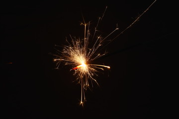 Christmas and New Year's illumination. Burning sparklers scatter bright exploding strips of sparks...