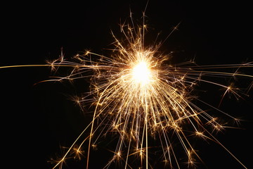 Christmas and New Year's illumination. Burning sparklers scatter bright exploding strips of sparks...