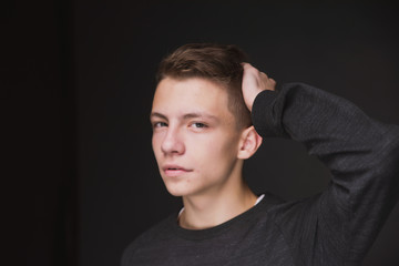 Beauty portrait of a beautiful young brown haired man on a gray background