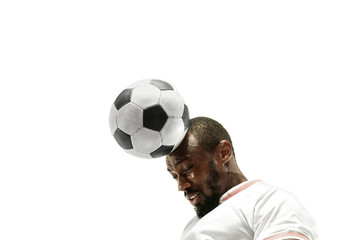 Close up of emotional african man playing soccer hitting the ball with the head on isolated white...