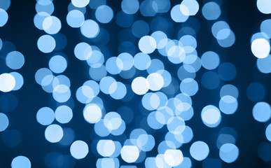 holiday illumination and background concept - christmas garland with classic blue lights bokeh