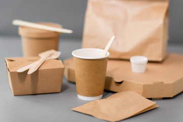 package, recycling and eating concept - disposable paper containers for takeaway food on table