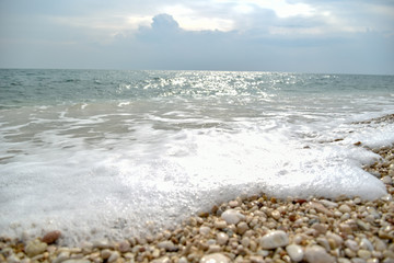 Foam of the Sea Waves on the Pebble Beach