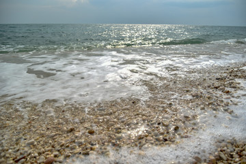 Foam of the Sea Waves on the Pebble Beach