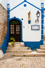 Front entrance of small chapel in Albufeira, West Portugal. Trendy monochrome image toned in classic blue, color of the year 2020.