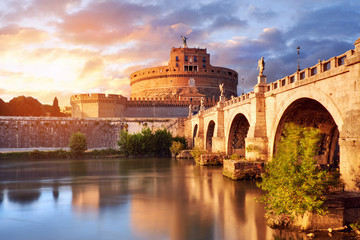 Saint Angelo Castle and bridge over the Tiber river in Rome, Italy, at sunset with beautiful...