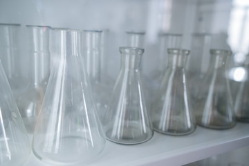 white orchid flower on glass flask and test tube in science cosmetic biology laboratory background