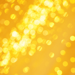 Naklejka na ściany i meble Beautiful golden Christmas light background with glowing backdrop glitter. Defocused background with gold blinking stars