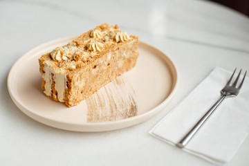 Coffee cake. A piece of cake on a plate. Sweet dessert on a round pink with a plate wooden background. Close-up.