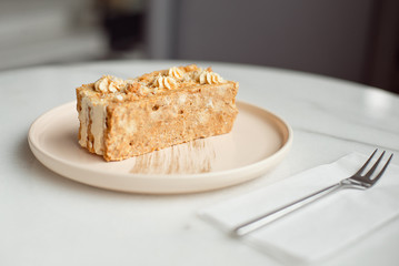 Coffee cake. A piece of cake on a plate. Sweet dessert on a round pink with a plate wooden background. Close-up.