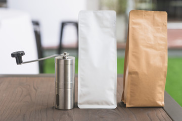 Blank brown and white paper bag and Coffee grinder on table