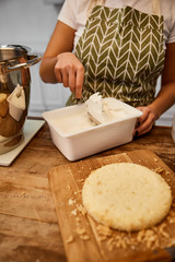 Selective focus of confectioner taking cream for cooking cake
