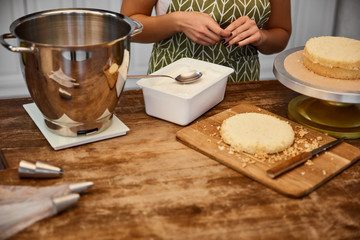 Selective focus of confectioner standing at table with ingredients for baking