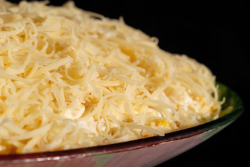Salad seasoned with mayonnaise and sprinkled with grated cheese. Shallow depth of field