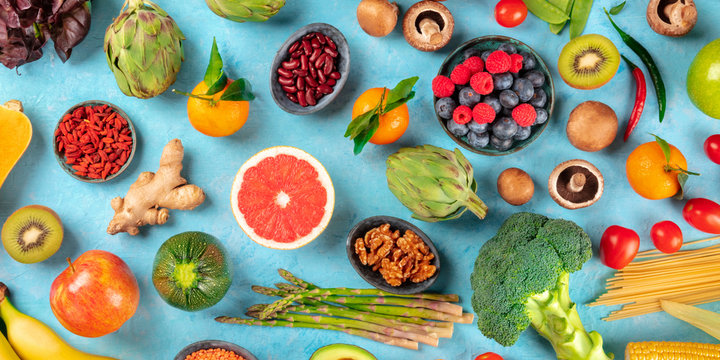 Vegan food panorama. Healthy diet concept. Fruits, vegetables, nuts, legumes, mushrooms, shot from the top on a blue background, a flatlay