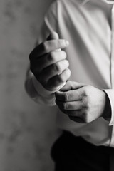 a man in a white shirt fastens the cuffs