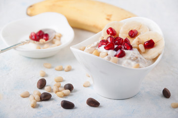 Oatmeal and yogurt smoothie with pomegranate, banana and pine nuts