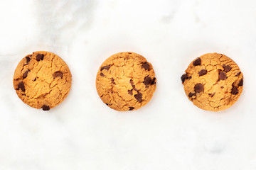 Chocolate chip cookies, gluten-free, top shot on a white marble background with copy space