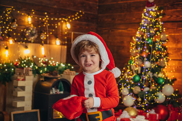 Christmas kid. Happy little smiling boy with Christmas gift socks. Happy kid having fun with gift.