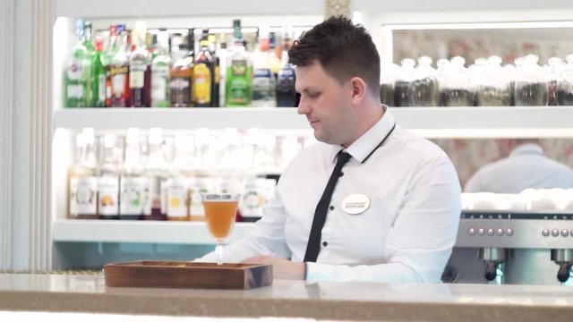 The bartender serves a cocktail of blood and sand using a gas burner