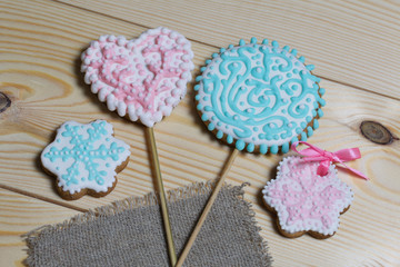 Spicy gingerbread cookie. On a stick and without it. Garnished with multicolored sugar glaze. Lies on pine boards.