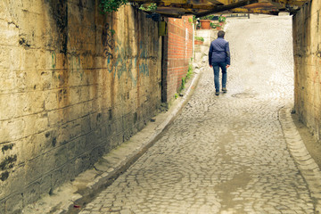 a man walks through an old stone tunnel