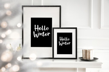 White frames on fireplace shelf and free space for your decoration.White wall decoration and christmas time. 