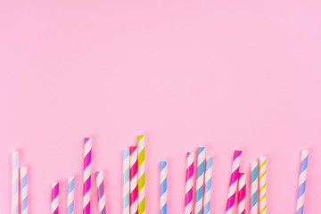 Colorful drinking straws on pink background. Birthday, party, menu, eco-friendly concept. Top view, flat lay, copy space