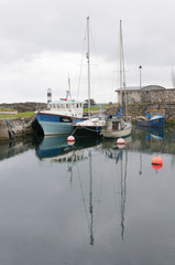 Fototapeta na wymiar Boats in the small harbor in fishing village of Carnlough, a town in Northern Ireland.