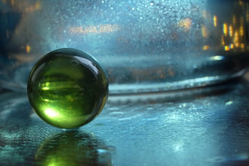 green glass ball on blue lurred backgroung