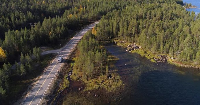 Aerial view of a camper van driving in Inarinjarvi, Lapland, North Finland, during the autumn.