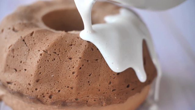 Traditional Homemade Marble Cake. Cream Pouring on Bundt Cake 