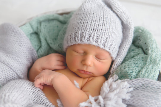 Newborn. Newborn boy sleeps in a basket. Gray-green colors.