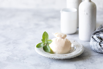 Italian burrata cheese on a round white plate on a light background. Copy space.