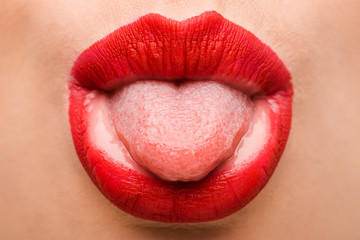 cropped view of girl with red lipstick sticking out tongue isolated on white