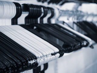 Obraz na płótnie Canvas Black and white coat hangers on a rack