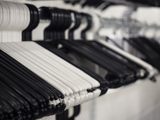 Obraz na płótnie Canvas Plastic black and white coat hangers on a rack