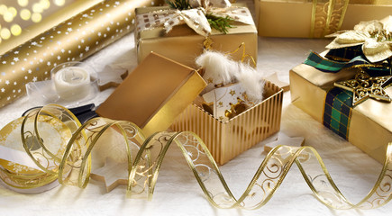 packing Christmas presents in glamour style with golden color paper