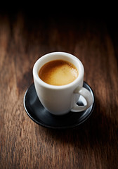 Cup of coffee on rustic wooden background. Close up.
