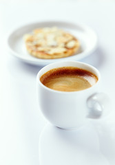 Cup of coffee and almond cookies on white background. Close up. 